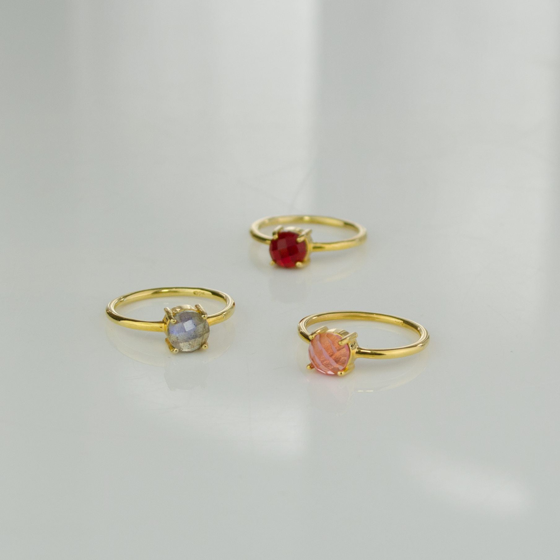 Assorted gold plated stackable prong set round ring. Birthstone jewelry, birthstone ring, stacking rings, ring stack, gemstone ring, gemstone rings. Gemstones shown are labradorite, garnet and pink chalcedony.