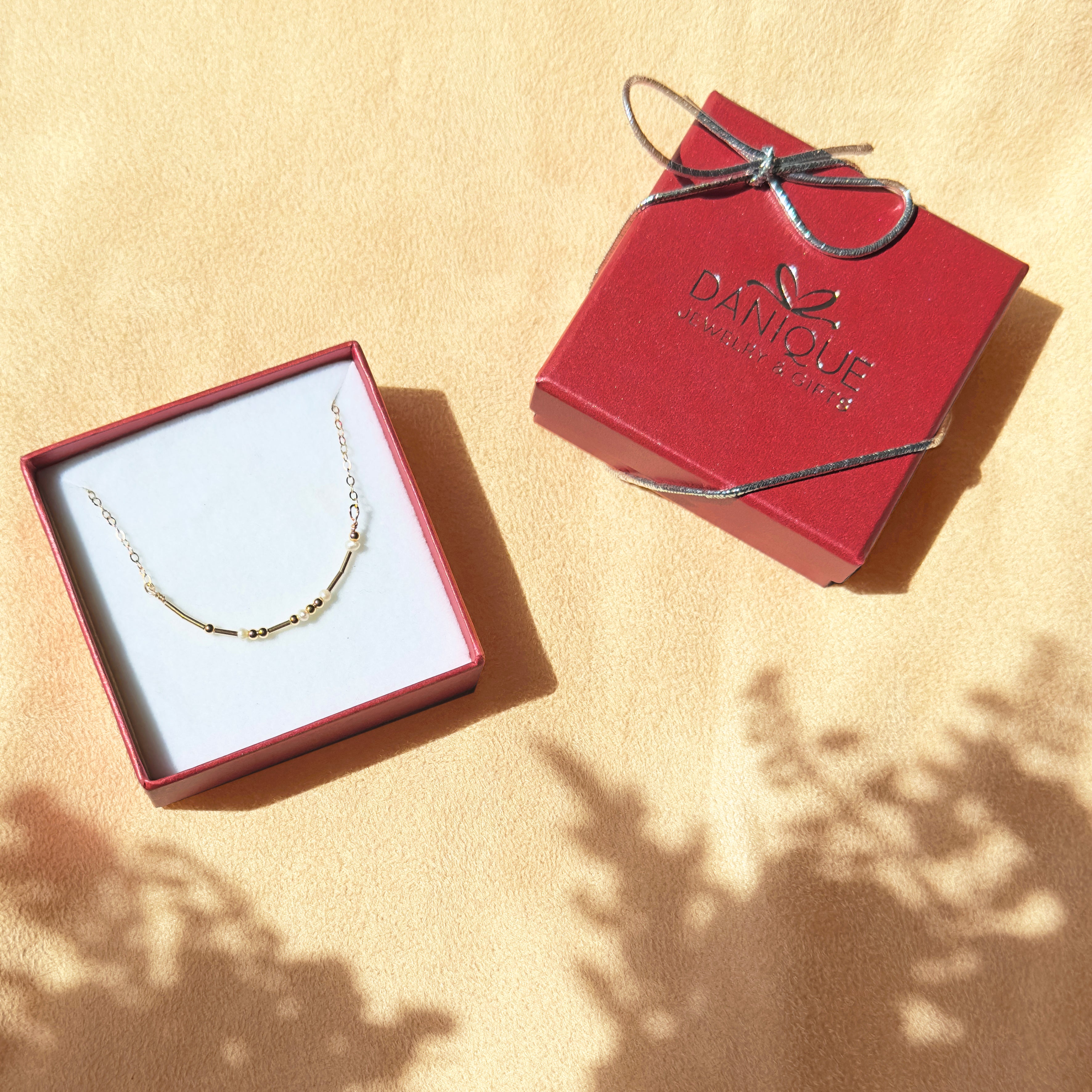 Gold Morse code beaded necklace with pearl spacers in signature danique jewelry gift box. freshwater pearls, bead jewelry, morse code beaded jewelry, secret message jewelry, bff jewelry, bff necklace, promise necklace, secret message necklace, hidden message jewelry, hidden message necklace, sterling silver, adjustable, delicate bead necklace, new product, delicate pattern of dots and dashes necklace. gifting ready, gift giving ready, birthday gift for her, christmas, mothers day gift for her