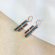 Rose gold boho style geometric branch pendant earrings on beige background. statement jewelry, statement boho necklace, purple, blue, gray, rose. bohemian jewelry,