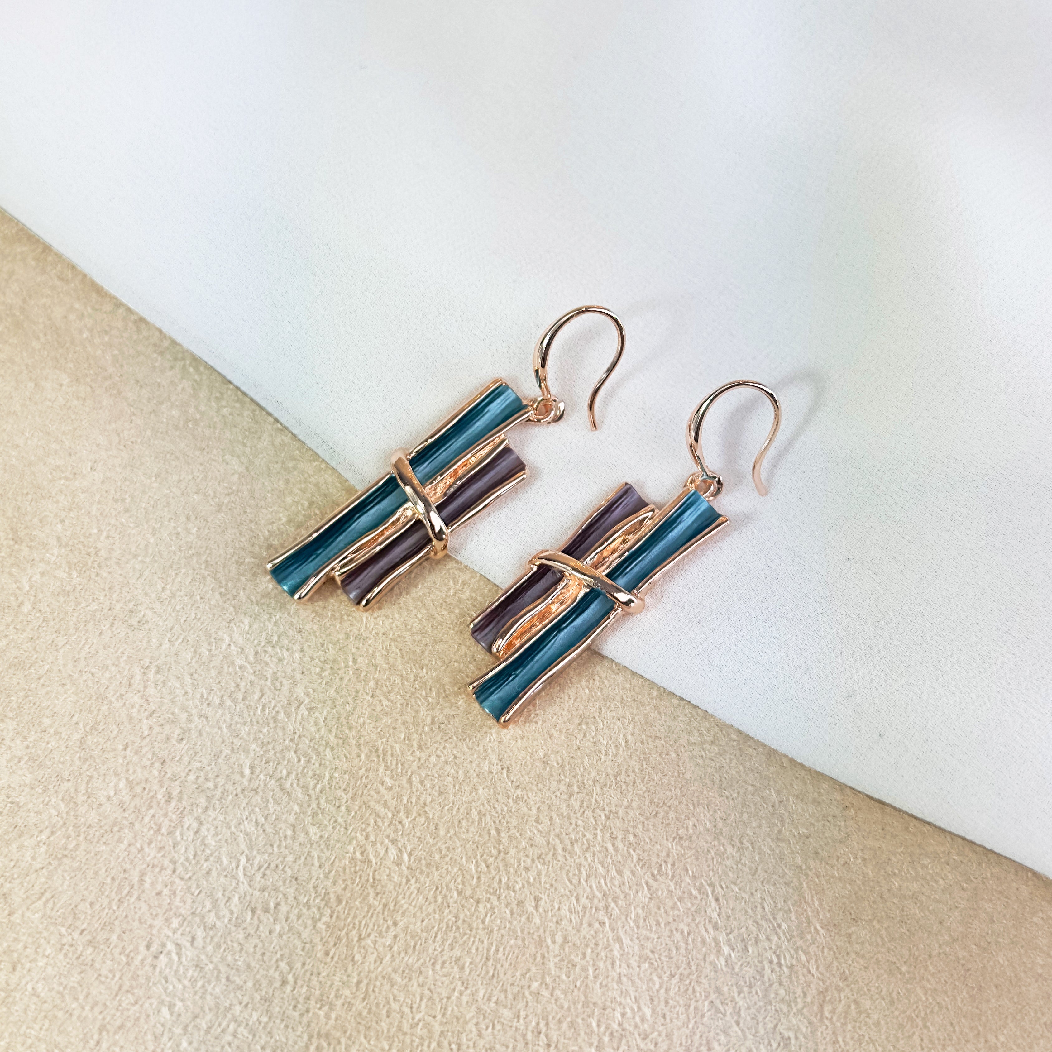 Rose gold boho style geometric branch pendant earrings on beige background. statement jewelry, statement boho necklace, purple, blue, gray, rose. bohemian jewelry,