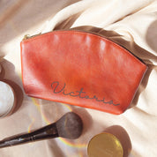 Custom engraved leather cosmetic bag in brown, personalized with name “Victoria.” Spacious design holds brushes, makeup, and essentials, making it the perfect bridesmaid gift, birthday present, or personalized travel pouch. A durable yet elegant custom cosmetic bag in full-grain leather, available in multiple colors with engraving options for initials, names, or handwriting.