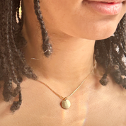 model wearing a gold initial necklace engraved with the letter R on a cable chain. Personalized initial disc gold, rose gold , or sterling silver necklace, custom necklace for graduation, letter pendant necklace, dainty initial necklace, gift for mom, custom name necklace, engraved graduation gift, layered charm necklace, unique initial pendant, gold filled necklaces with initials, letter necklaces, initial jewelry for women, dainty trendy initial necklace round disc, pendant necklace engravable