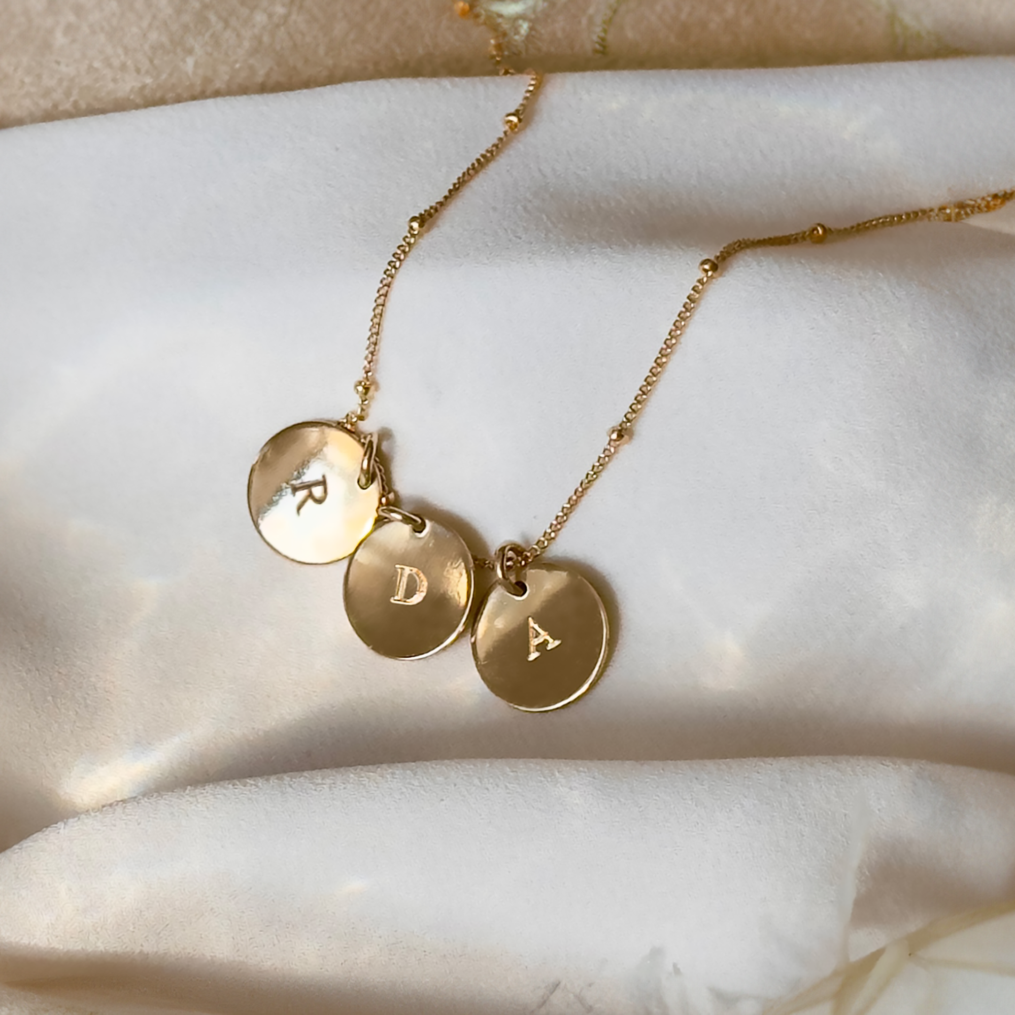 Gold satellite 3 disc initial necklace with letters r, d, a engraved. Personalized initial disc gold, rose gold , or sterling silver necklace, custom necklace for graduation, letter pendant necklace, family tree jewelry, dainty initial necklace, gift for mom, custom name necklace, engraved graduation gift, layered charm necklace, unique initial pendant, gold filled necklaces with initials, letter necklaces, initial jewelry for women, dainty trendy initial necklace round disc, pendant necklace engravable