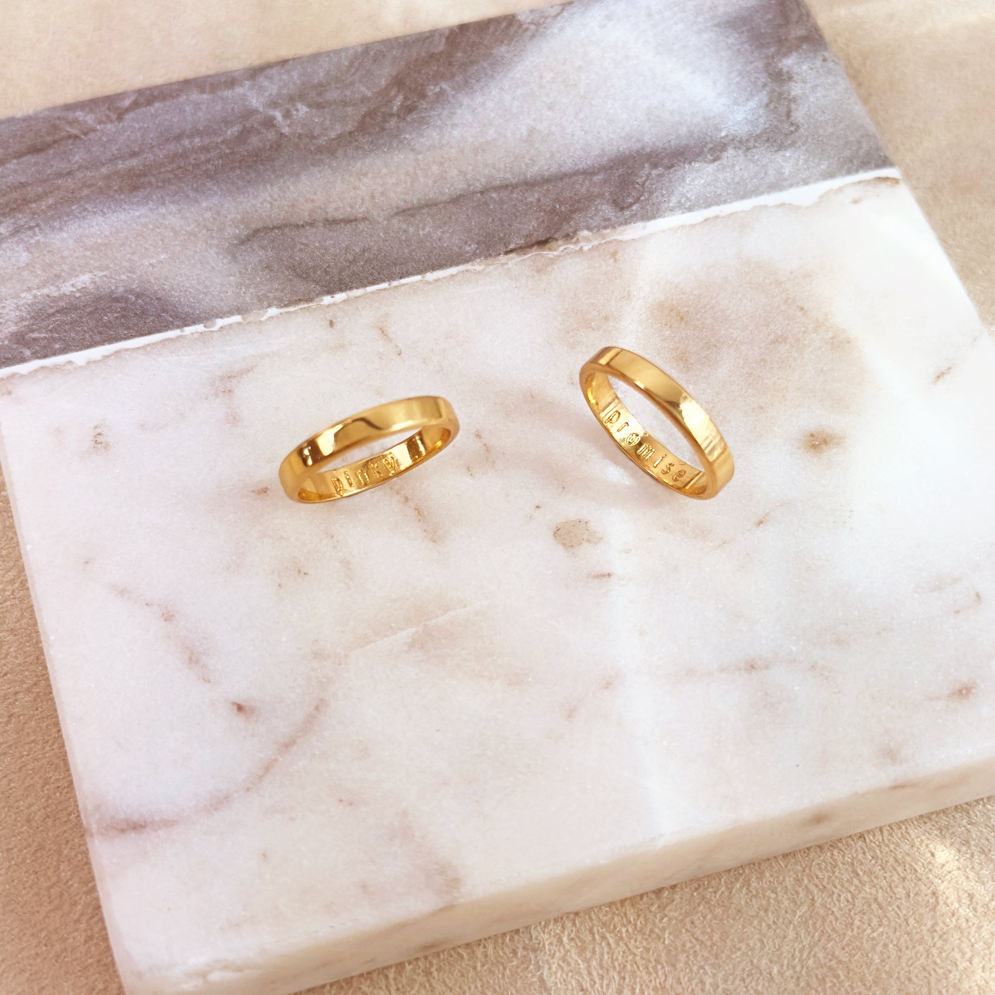 Two engraved gold rings with inside engravings. One ring says pinky and the other says promise. Personalized custom engraved thin rings, stackable thin rings, custom name rings, gold rings for men and women anniversary, custom engraved sterling silver promise rings, sterling silver wedding rings for men and women