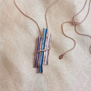 Rose gold boho style geometric branch pendant necklace on beige background. statement jewelry, statement boho necklace, purple, blue, gray, rose. bohemian jewelry,