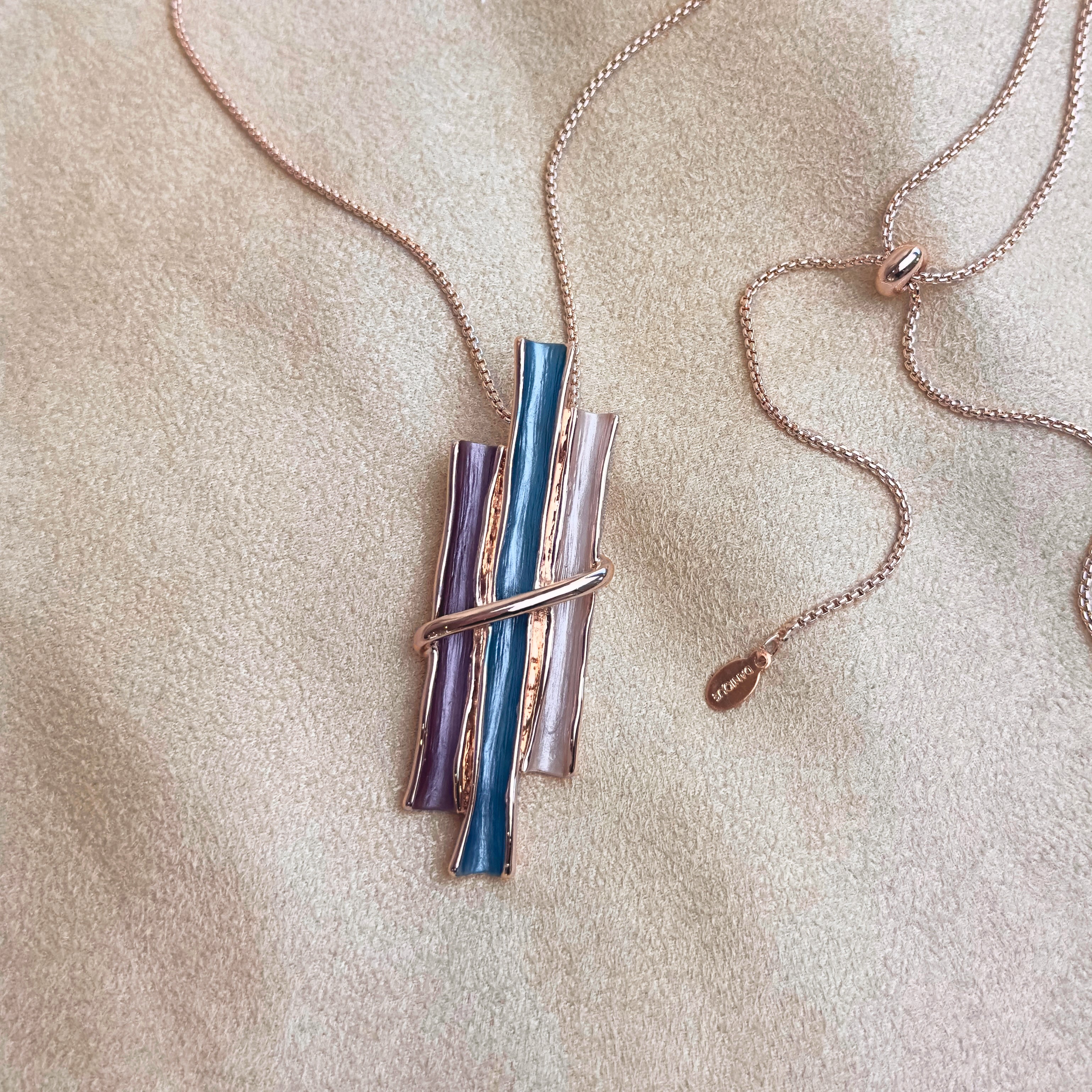 Rose gold boho style geometric branch pendant necklace on beige background. statement jewelry, statement boho necklace, purple, blue, gray, rose. bohemian jewelry,