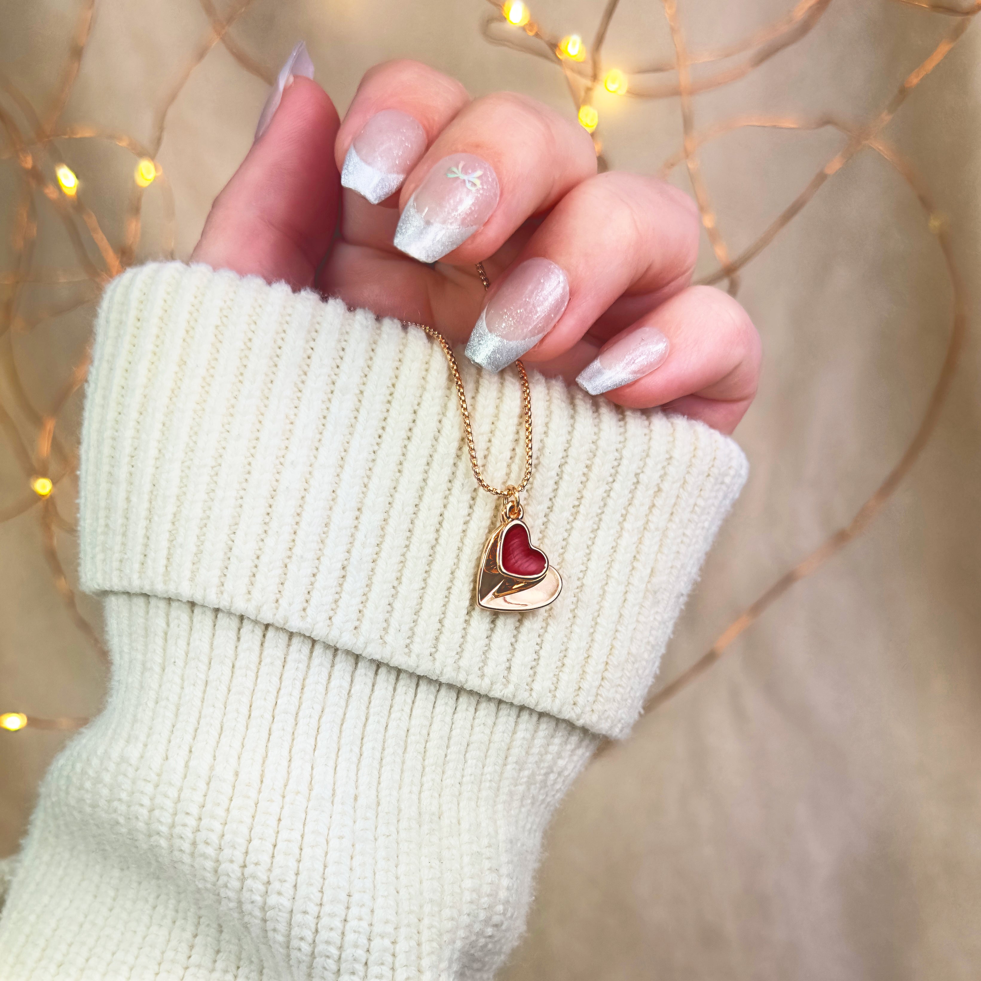 Model holding a Rose gold double hearts pendant necklace. Heart charms, heart necklace, statement necklace, bohemian jewelry, boho jewelry