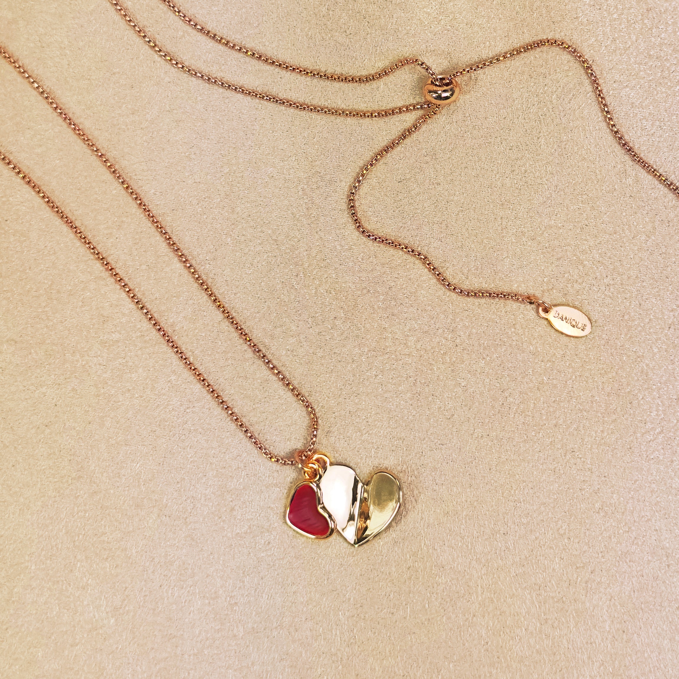 Rose gold double hearts pendant necklace on beige background. Heart charms, heart necklace, statement necklace, bohemian jewelry, boho jewelry