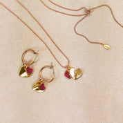Rose gold double hearts pendant necklace and hoop dangle earrings set on beige background. Heart charms, heart necklace, statement necklace, bohemian jewelry, boho jewelry
