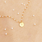 Gold wire wrapped pearl bracelet with disc engraved with the letter R on a beige background. Dangling pearl charm optional. Nature inspired jewelry, gift for mom, nature bracelet, dainty bracelet, charm bracelet