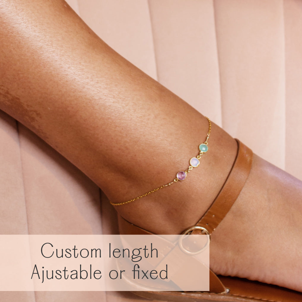 Personalized ankle bracelet with bezel-set gemstones in gold, shown on ankle with sandal strap. This elegant anklet is available in custom adjustable or fixed lengths and makes a meaningful jewelry gift for sisters, best friends, or loved ones. Ideal as a friendship anklet, matching anklet set, or thoughtful birthday, Christmas, or anniversary gift. Handmade in sterling silver, gold filled, or rose gold filled, this dainty ankle bracelet captures love, family, and friendship in a timeless keepsake.