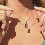 Video: custom birthstone baguette necklace with side engraving on 14k gold filled chain. Rectangular bar pendants shown in multiple colors; available for all birth months (Garnet–January through Blue Topaz–December). Minimalist, personalized name/date necklace, layered and gift-ready.