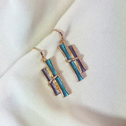 Rose gold boho style geometric branch pendant earrings on beige background. statement jewelry, statement boho necklace, purple, blue, gray, rose. bohemian jewelry,