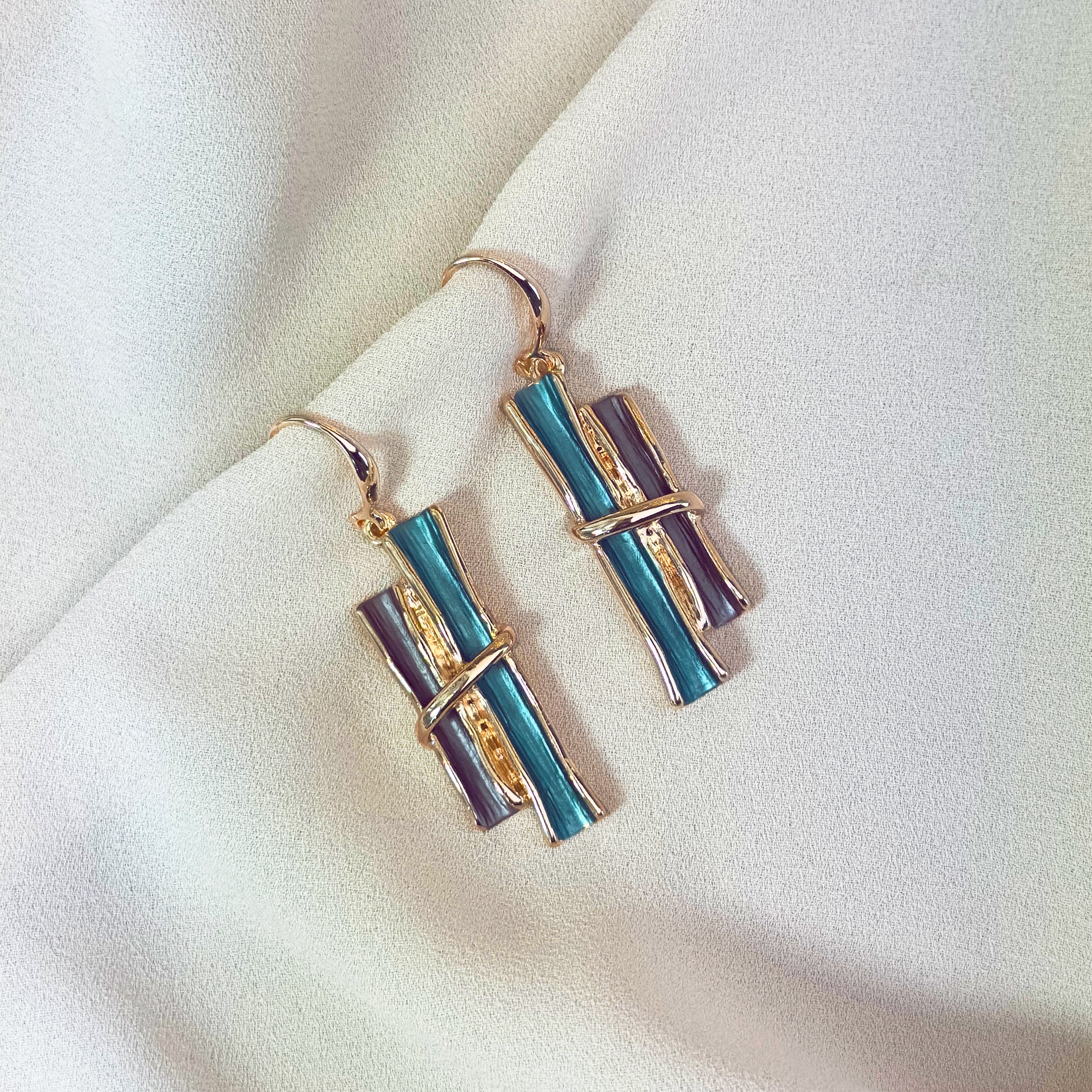 Rose gold boho style geometric branch pendant earrings on beige background. statement jewelry, statement boho necklace, purple, blue, gray, rose. bohemian jewelry,