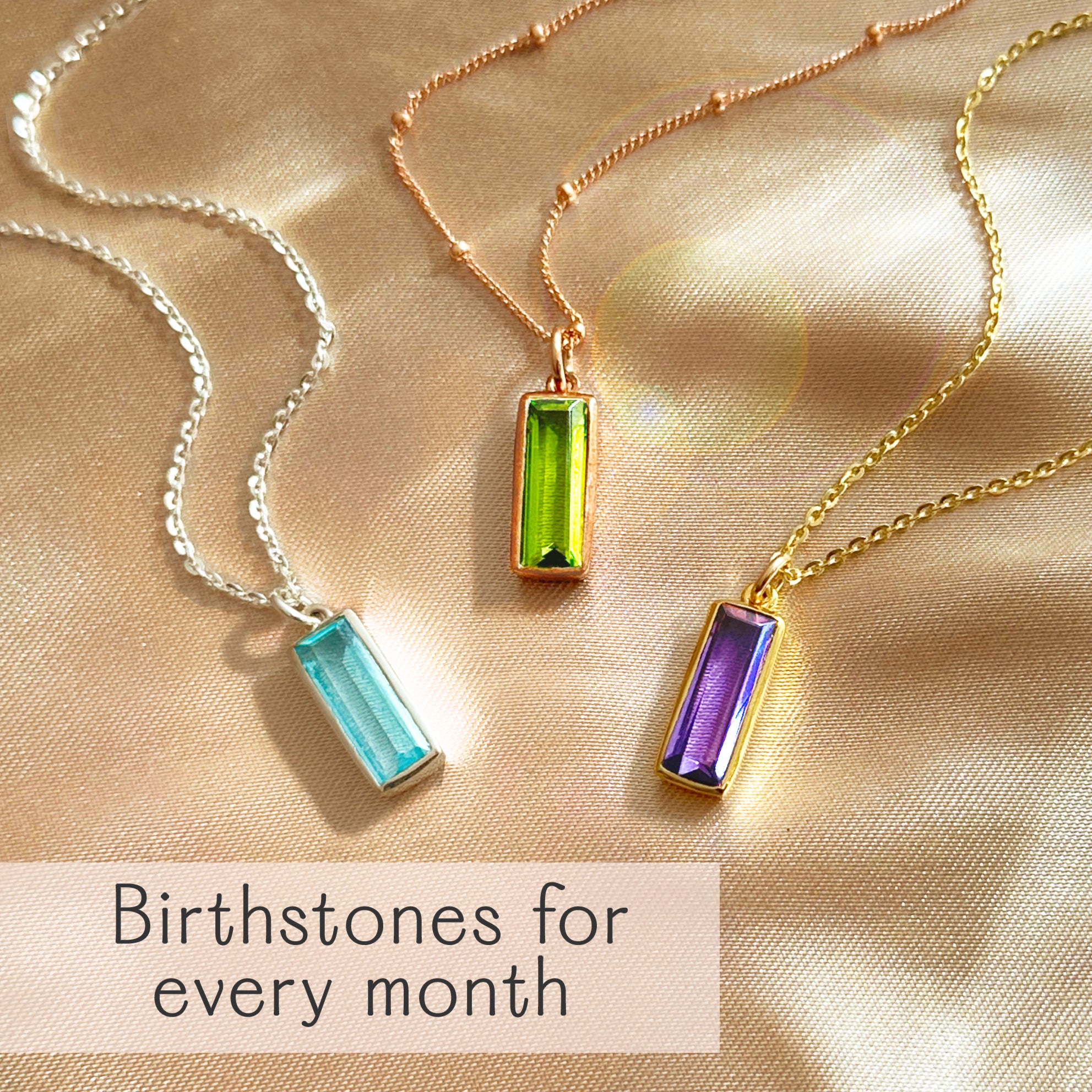 Baguette birthstone necklaces in .925 sterling silver and 18K vermeil (yellow/rose), shown with aquamarine March, peridot August, and amethyst February stones. Minimalist bar pendant, option for custom engraving—birthstones for every month.