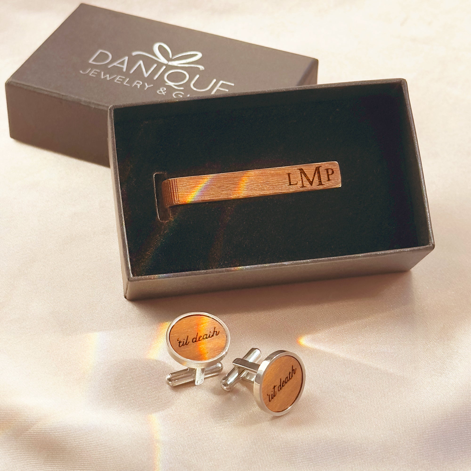Rustic wooden cufflink and tie bar set with personalized engraving, presented in a Danique Jewelry gift box. The custom tie clip features engraved initials while the round cufflinks display “’til death” design, creating a unique and stylish men’s accessory set. Perfect for rustic weddings, groomsmen proposals, anniversary gifts, or personalized business attire. A thoughtful gift for husband, boyfriend, or dad to wear on formal occasions and keep as a lasting keepsake.