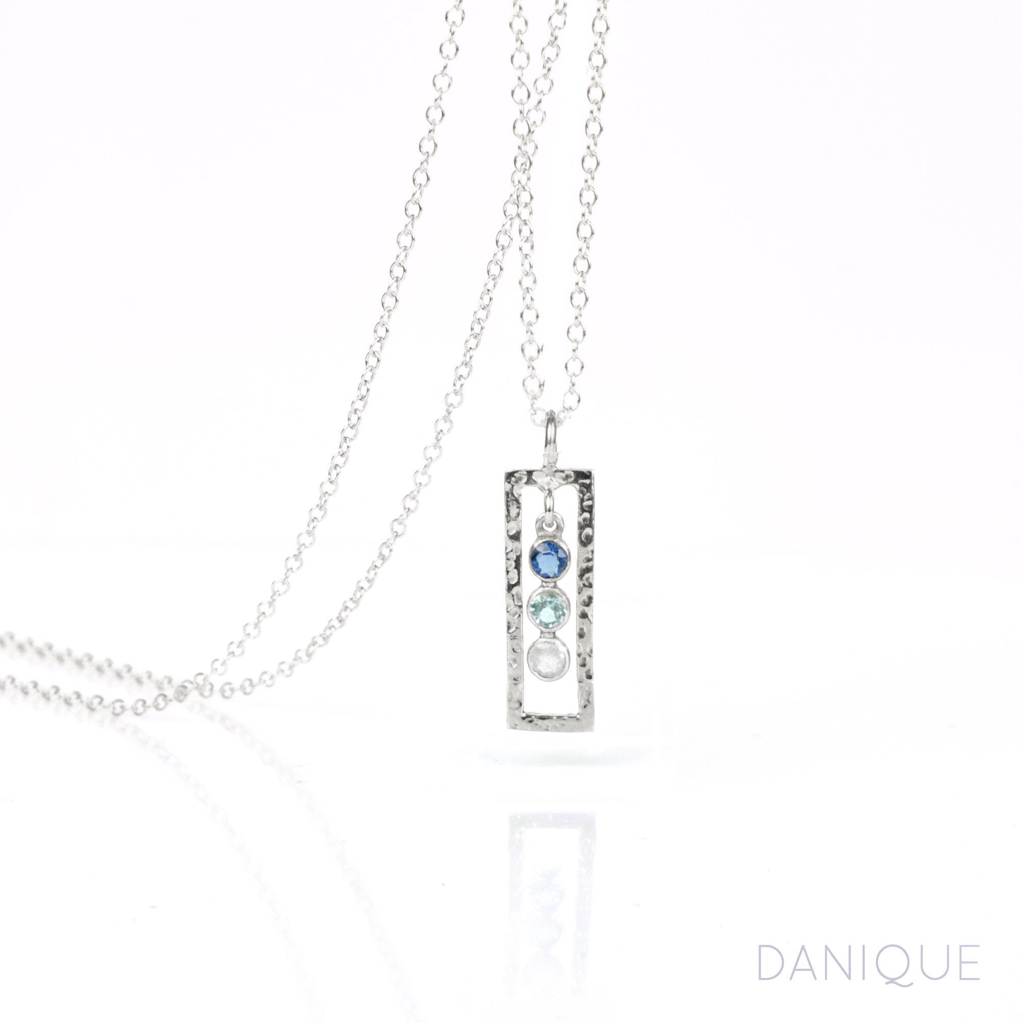 Single sterling silver open frame necklace with kyanit, blue topaz and moonstone birthstones.