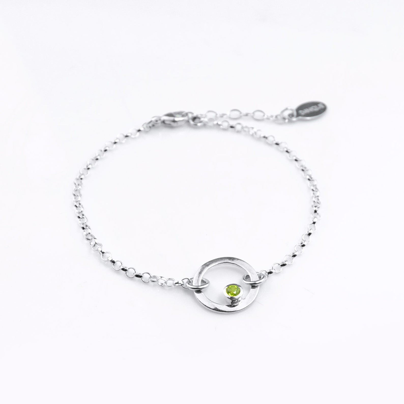 Sterling silver open circle pendant charm birthstone bracelet featuring peridot birthstone. August birthstone, gemstone jewelry on white background.