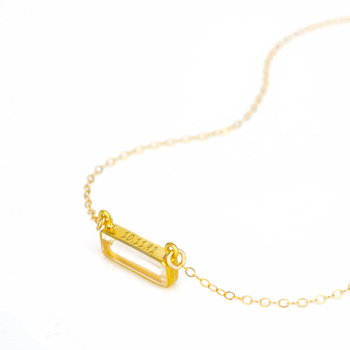 gold filled cable chain horizontal clear quartz birthstone with secret message engraved on top of bar.
