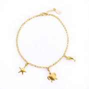 Single gold charm anklet with starfish, turtle and dolphin charms and lobster clasp.