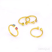 Collection of four custom gold filled dual birthstone rings featuring kyanite, ruby, peridot, citrine, clear, and purple amethyst. Back of citrine and peridot ring shown