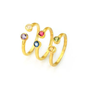 Collection of three custom gold filled dual birthstone rings featuring kyanite, ruby, peridot, citrine, clear, and purple amethyst on white background.