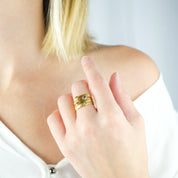 Model in white top is wearing a collection of four stacking rings gold plated name bar rings with purple amethyst, iolite, ruby and peridot birthstones. engraved name ring, birthstone jewelry, birthstone ring