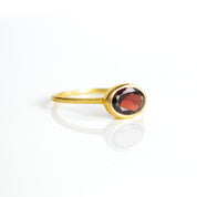 a gold garnet ring shown on white background. stackable! Stacking rings, bezel set, birthstone jewelry, red gemstone, red birthstone, january birthstone, january gemstone, stack set, stacking rings, gemstone ring, birthstone ring, mother's day gift for her, gift for mom, gift for fiance, gift for girlfriend, wedding jewelry, bridesmaid jewelry, anniversary jewelry, anniversary gift, birthday gift, christmas gift, valentine's day gift, valentine's day rings, dainty ring, cocktail ring, statement ring