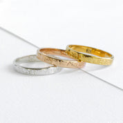 Custom 3mm engraved rings in gold and silver placed side by side on marble background. Slim unisex bands personalized with engraved names, dates, or coordinates. Minimalist and dainty, these rings are perfect for couples as wedding bands, promise rings, or anniversary gifts. Available in sterling silver, gold vermeil, and rose gold vermeil, handcrafted with lasting quality engraving.