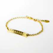 A gold-filled sonogram bracelet is laying flat against a white background. This heart beat jewelry can be engraved with a custom ekg, ultrasound or sonogram to capture your babys first signs of life! Ultrasound jewelry, sonogram jewelry, ekg jewelry