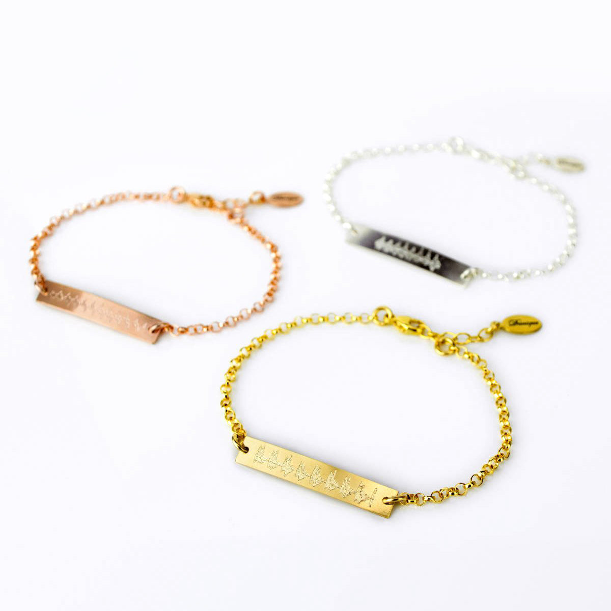 3 ultrasound bracelets in silver, rose gold and gold lay against a white background. What better gift for a new mom than her babys first heartbeat forever preserved in an elegantly simple bracelet? Perfect for her first Mothers Day!