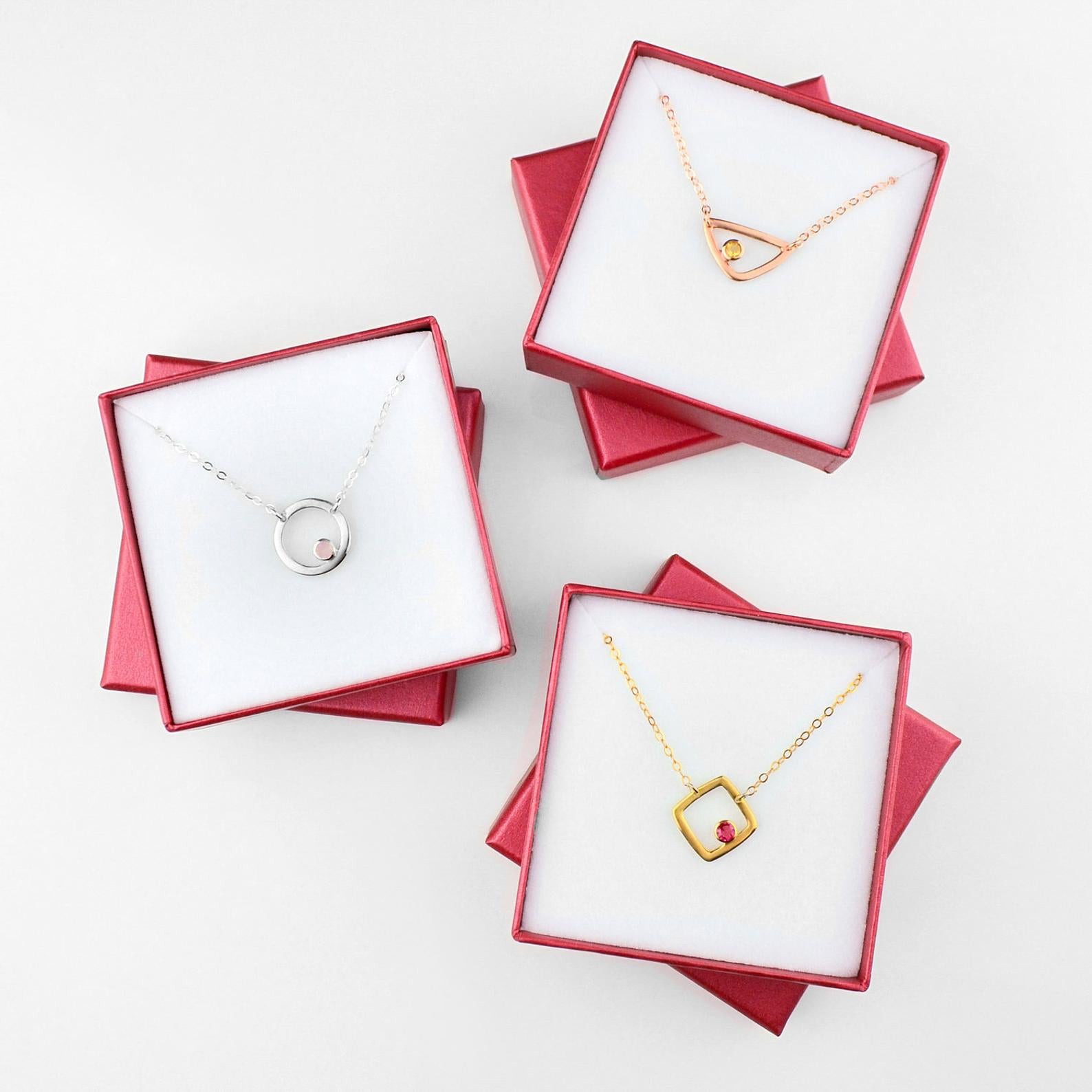 Shop the entire eden series collection. Gifting ready! Gift giving ready. Each piece will come packaged in our signature Danique Jewelry Gift box. Collection of silver open circle with pink chalcedony, rose gold triangle with citrine birthstone or gold square with ruby birthstone.