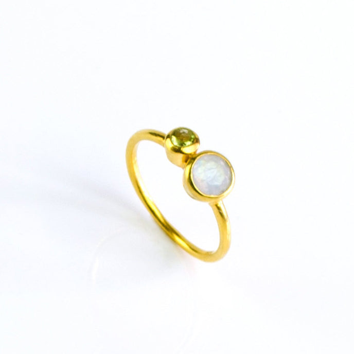 One mothers duel bezel set ring in gold filled featuring a 5mm moonstone and 3mm peridot birthstones on white background.