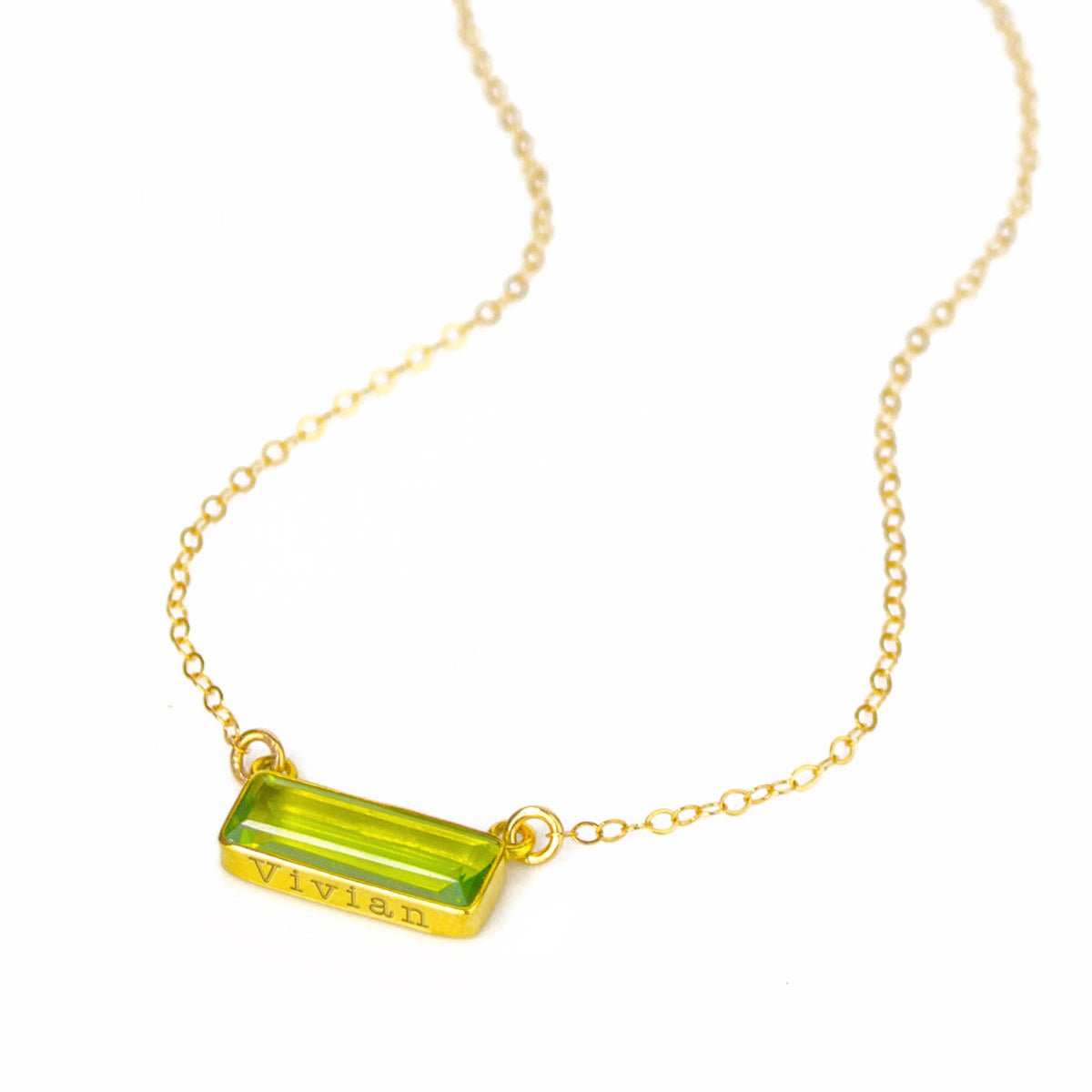 Gold filled cable chain horizontal adira bar peridot august birthstone necklace with secret message engraved on bottom in typewriter font.