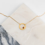 Single gold filled open circle geometric necklace with garnet birthstone. January birthstone.