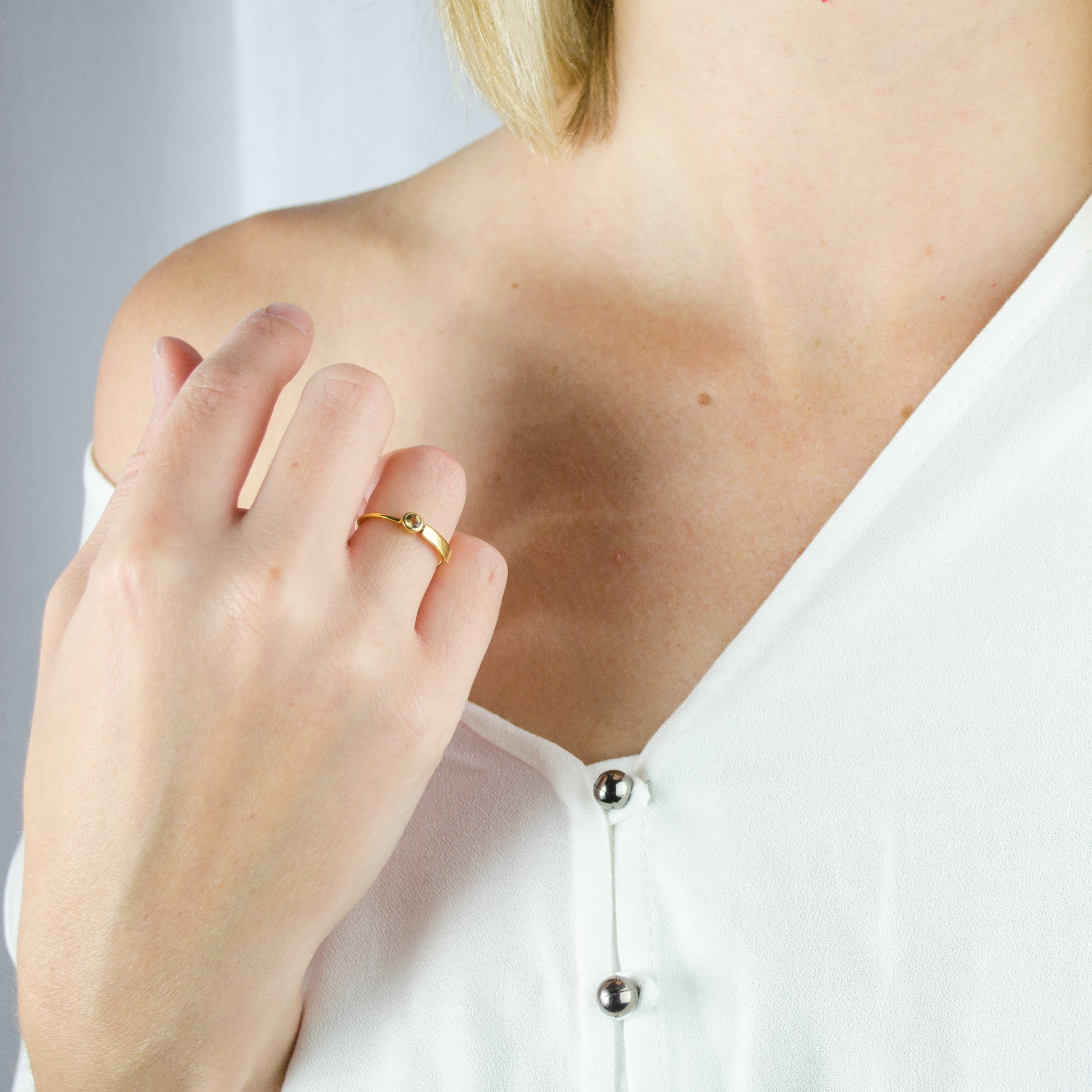 Model in white top is wearing a gold plated name bar rings peridot birthstones. engraved name ring, birthstone jewelry, birthstone rings