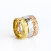 Stacked fingerprint engraved rings in gold, silver, and rose gold displayed together, featuring deep fingerprint impressions and personalized engravings inside and outside. These custom fingerprint bands are ideal as wedding rings, commitment rings, or memorial keepsakes, offering a meaningful way to preserve a loved one’s touch. Handcrafted from sterling silver and vermeil gold, each ring is uniquely personalized for couples, anniversaries, and family heirloom jewelry.