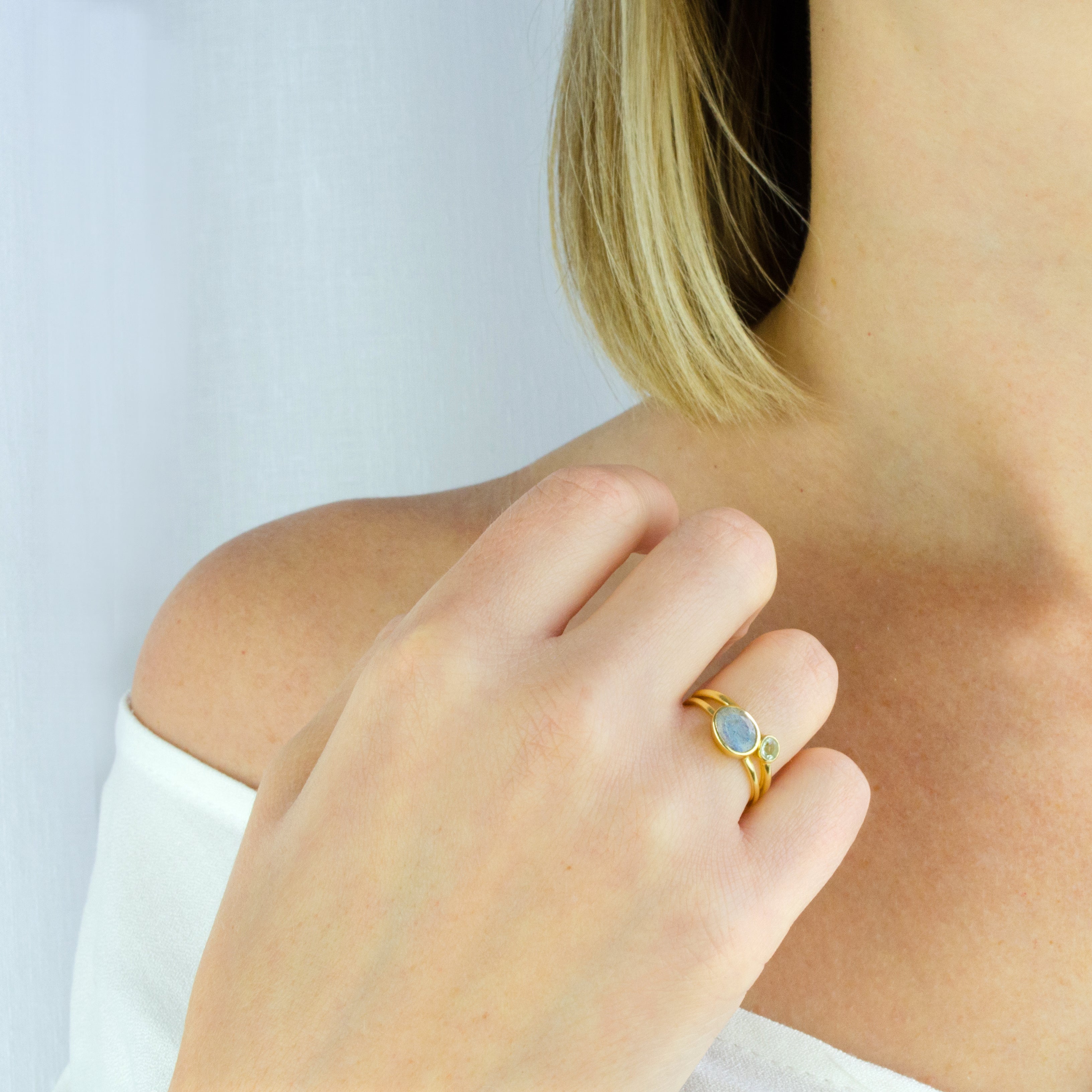 Model wearing the labradorite and green amethyst stacking small rings in gold
