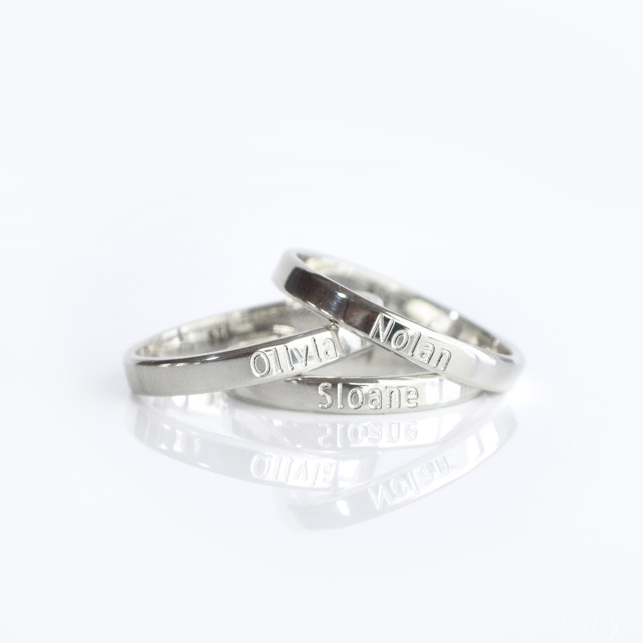 Pair of sterling silver 3mm engraved rings displayed together on a white background. Slim minimalist bands personalized with text engraving such as names, dates, or coordinates, making them perfect for couple’s rings, promise rings, or wedding bands. This dainty design is unisex, handcrafted, and available in sterling silver, gold vermeil, and rose gold vermeil.