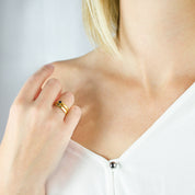 Model in white top is wearing a collection of two stacking rings gold plated name bar rings iolite, peridot birthstones. engraved name ring, birthstone jewelry, birthstone rings