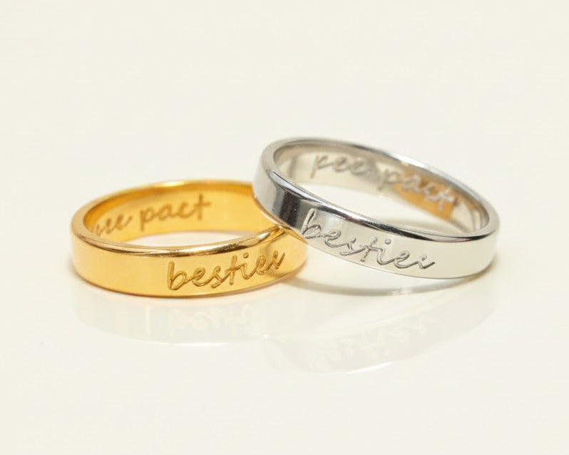 Two rings, one gold and one silver, engraved with "bestie" on the outside. The inside features a "pinky pact" engraving. A perfect personalized gift for Galentine's Day.