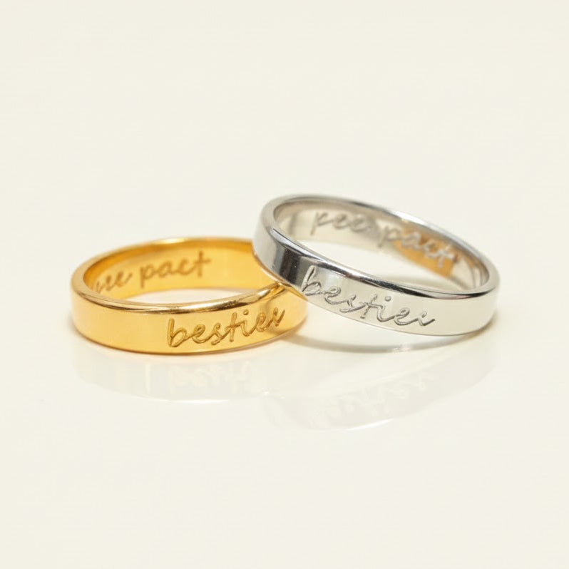 Two rings, one gold and one silver, engraved with "bestie" on the outside. The inside features a "pinky pact" engraving. A perfect personalized gift for Galentine's Day.