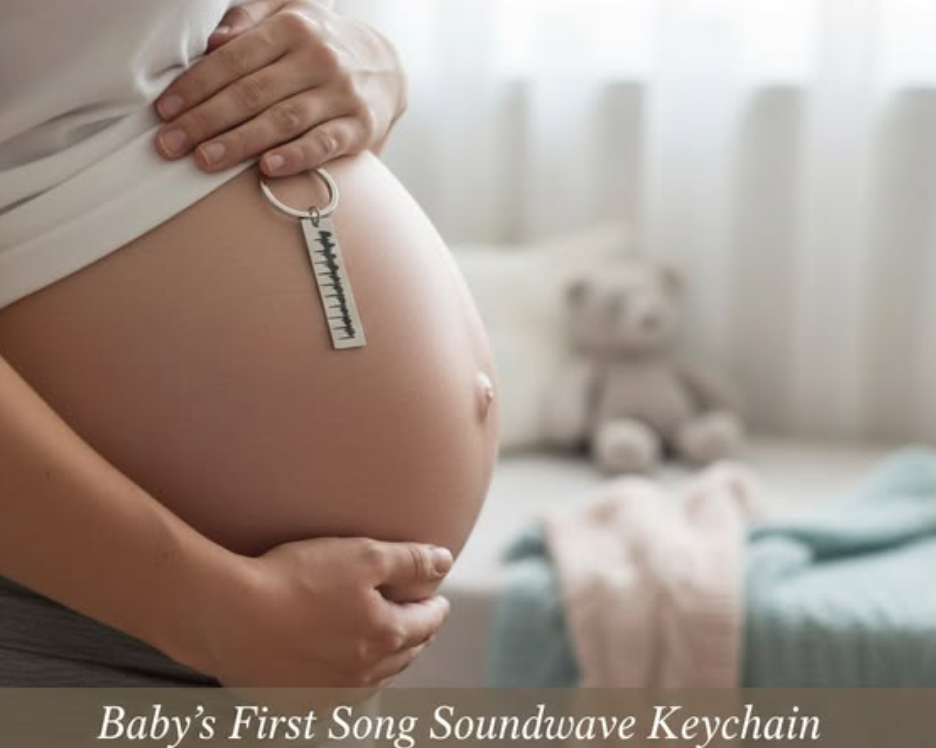 Pregnant woman holding her baby bump with a silver soundwave keychain resting against her belly, styled in a soft nursery setting with text about baby’s first song and a gift for mom-to-be.