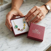 Colorful beaded necklace in a Danique jewelry box on a marble surface