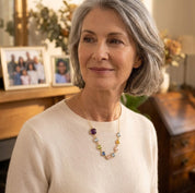 Woman with gray hair wearing a custom birthstone necklace for grandma which represents her grandkids