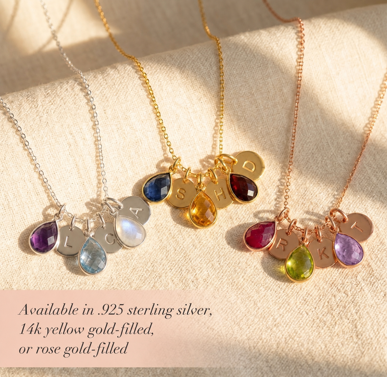 Gold, silver, and rose gold mom birthstone necklaces with colorful gemstone charms and initial discs on soft fabric.