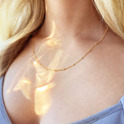 Rose gold filled Dew Drops satellite chain necklace arranged in a gentle curve, emphasizing its dainty scale, warm tone, and elegant bead spacing ideal for a feminine everyday choker