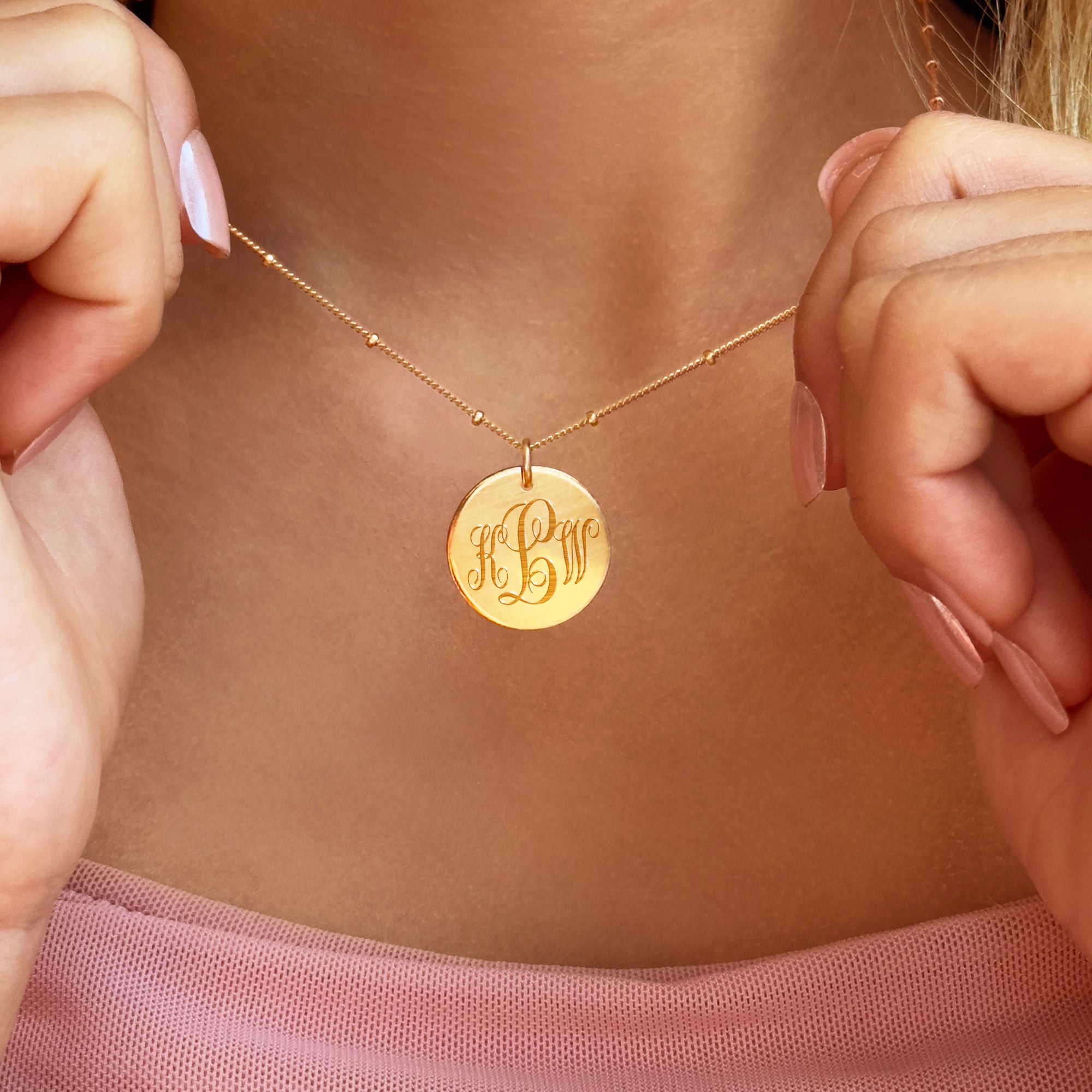 Woman wearing personalized gold monogram necklace, engraved initial disc pendant, elegant custom jewelry gift for her