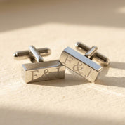 Silver rectangular bar cufflinks engraved with personalized initials in a modern monogram style.