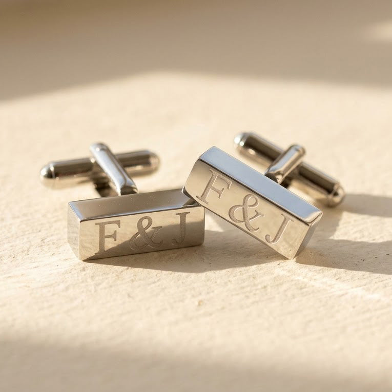 Silver rectangular bar cufflinks engraved with personalized initials in a modern monogram style.